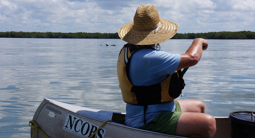 A person paddles a canoe on an outward bound veterans expedition.