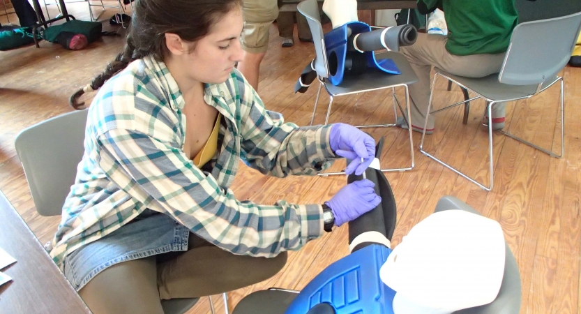A person wraps an ankle as part of a wilderness first responder course. 